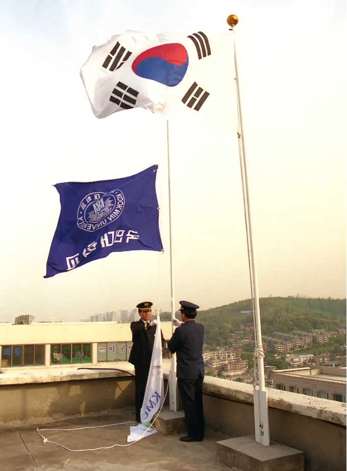 2001년 옛 교기를 내리고 새로운 교기를 올리는 장면의 흐림 배경